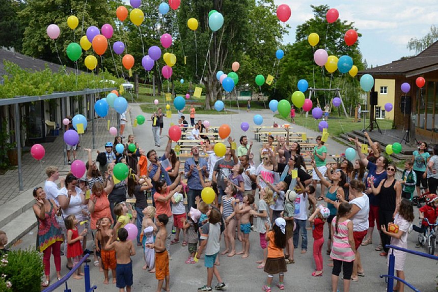 Olympiaworld Innsbruck eine jubelnde Menge aus Erwachsenen und Kindern mit vielen Luftballonen