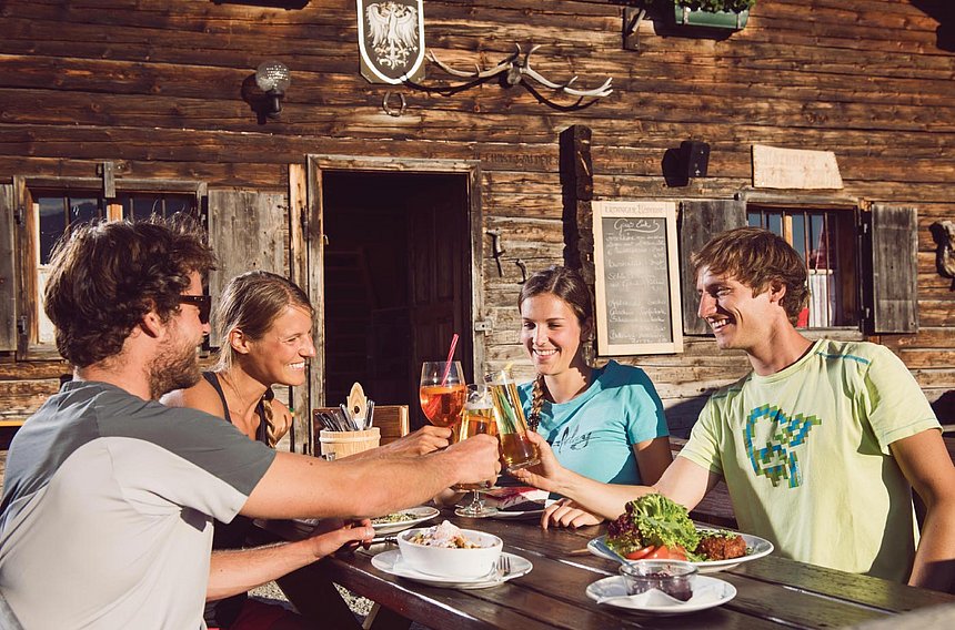 Olympiaworld Innsbruck guests eating in front of a mountain hut