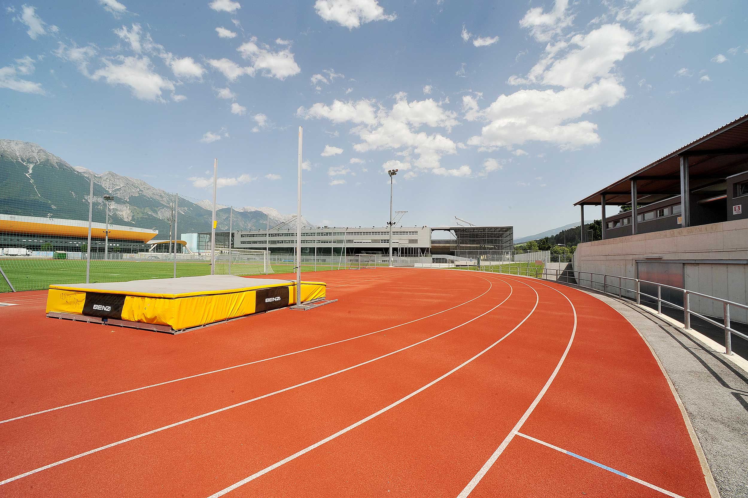 Olympiaworld Innsbruck Beachvolleyballplatz mit Spielern  Olympiaworld Innsbruck Eisfläche Außenbereich mit Eisläufern  Olympiaworld Innsbruck Laufbahn Leichtathletikanlage